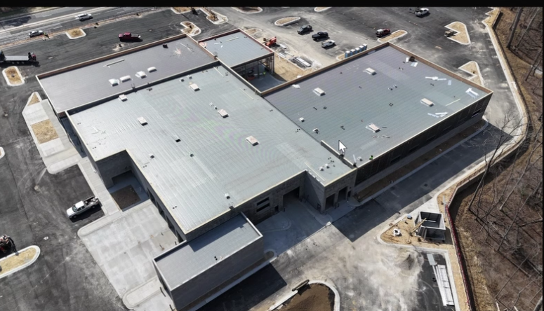 Aerial overhead view of the Mercedes-Benz of Buford construction site showing the full building footprint and roofing progress.